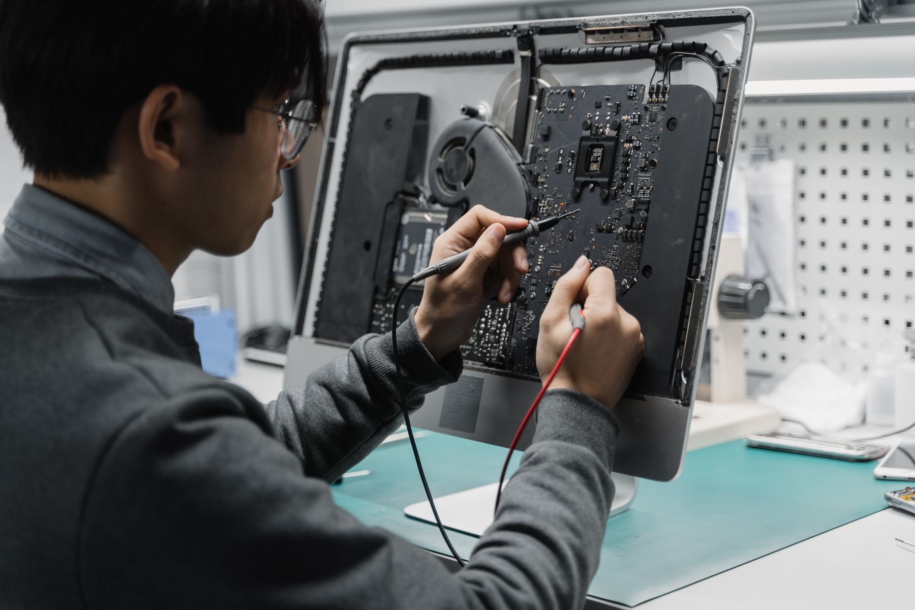 Técnico realizando diagnóstico eletrônico em um computador